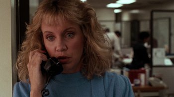 Movie still from “Lethal Weapon” (1987), directed by Richard Donner – A woman talking on a phone in an office setting; Close Up shot, Low angle
