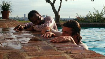 Movie still from “Lethal Weapon” (1987), directed by Richard Donner – Two men leaning on the side of a pool; Medium shot, Over the shoulder angle