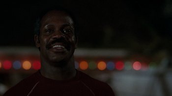 Movie still from “Lethal Weapon” (1987), directed by Richard Donner – A person smiling at the camera; Close Up shot, Low angle