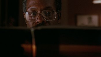 Movie still from “Lethal Weapon” (1987), directed by Richard Donner – A man wearing glasses looking at a laptop; Close Up shot, Low angle