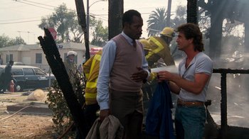 Movie still from “Lethal Weapon” (1987), directed by Richard Donner – Two men standing next to each other near a tree; Medium shot, Over the shoulder angle