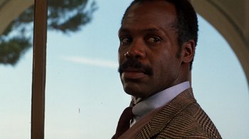 Movie still from “Lethal Weapon” (1987), directed by Richard Donner – A person wearing a suit and a tie; Close Up shot, Low angle