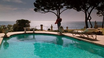 Movie still from “Lethal Weapon” (1987), directed by Richard Donner – A man standing on the edge of a swimming pool; Extreme Wide shot, High angle