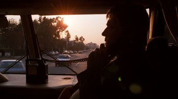 Movie still from “Lethal Weapon” (1987), directed by Richard Donner – A person sitting in a car on a street; Close Up shot, Low angle