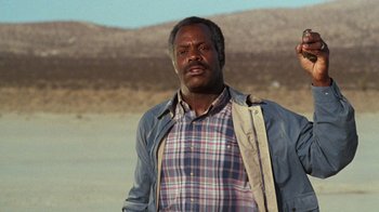 Movie still from “Lethal Weapon” (1987), directed by Richard Donner – A man standing in the middle of the desert; Close Up shot, Low angle