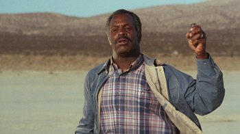Movie still from “Lethal Weapon” (1987), directed by Richard Donner – A man standing in the middle of the desert; Close Up shot, Low angle