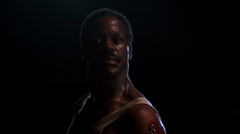 Movie still from “Lethal Weapon” (1987), directed by Richard Donner – A man with a bandage on his arm and chest; Close Up shot, Low angle