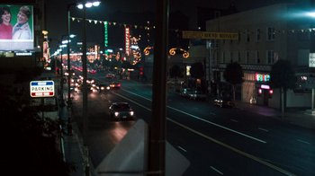 Movie still from “Lethal Weapon” (1987), directed by Richard Donner – A car driving down a street at night with lights on; Extreme Wide shot, High angle