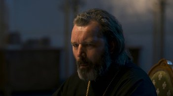Movie still from “Leviathan” (2014), directed by Andrey Zvyagintsev – A man with long hair and a beard wearing a black shirt; Close Up shot, Low angle