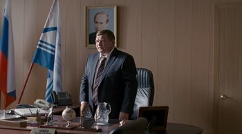Movie still from “Leviathan” (2014), directed by Andrey Zvyagintsev – A man standing in front of a desk in an office setting; Medium shot, Over the shoulder angle