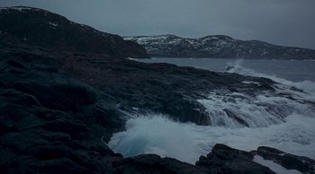 Movie still from “Leviathan” (2014), directed by Andrey Zvyagintsev – A body of water near a rocky shore with snow capped mountains in the background; Extreme Wide shot, High angle
