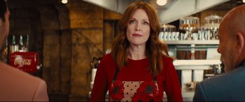 Movie still from “Kingsman: The Golden Circle” (2017), directed by Matthew Vaughn – A person wearing an apron in a room; Medium shot, Low angle