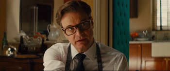 Movie still from “Kingsman: The Golden Circle” (2017), directed by Matthew Vaughn – A person wearing glasses and a tie; Close Up shot, Over the shoulder angle