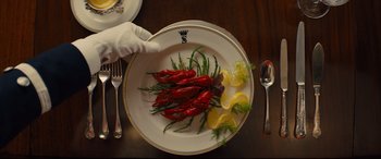 Movie still from “Kingsman: The Golden Circle” (2017), directed by Matthew Vaughn – A plate of food on top of a wooden table; Extreme Close Up shot, High angle