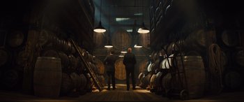 Movie still from “Kingsman: The Golden Circle” (2017), directed by Matthew Vaughn – Two men are standing in a wine cellar; Wide shot, Low angle