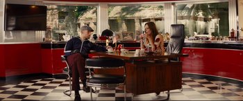 Movie still from “Kingsman: The Golden Circle” (2017), directed by Matthew Vaughn – A man and a woman sitting at a table in a restaurant; Wide shot, Over the shoulder angle