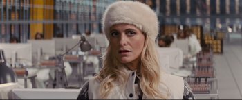Movie still from “Kingsman: The Golden Circle” (2017), directed by Matthew Vaughn – A woman with long blonde hair wearing a white fur hat; Close Up shot, Over the shoulder angle