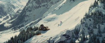 Movie still from “Kingsman: The Golden Circle” (2017), directed by Matthew Vaughn – A ski slope covered in snow with a ski lodge in the background; Extreme Wide shot, High angle