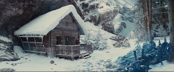 Movie still from “Kingsman: The Golden Circle” (2017), directed by Matthew Vaughn – A person standing outside of a log cabin in the snow; Extreme Wide shot, High angle