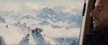 Movie still from “Kingsman: The Golden Circle” (2017), directed by Matthew Vaughn – A view of a snowy mountain range from a plane window; Extreme Wide shot, High angle
