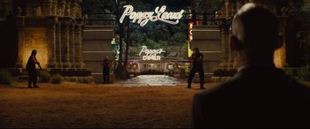 Movie still from “Kingsman: The Golden Circle” (2017), directed by Matthew Vaughn – Two people are standing in front of a neon sign; Extreme Wide shot, Over the shoulder angle