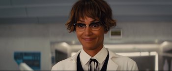 Movie still from “Kingsman: The Golden Circle” (2017), directed by Matthew Vaughn – A woman in a white lab coat and glasses; Close Up shot, Over the shoulder angle