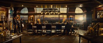 Movie still from “Kingsman: The Golden Circle” (2017), directed by Matthew Vaughn – A group of people sitting at a table in front of a large window; Extreme Wide shot, Low angle
