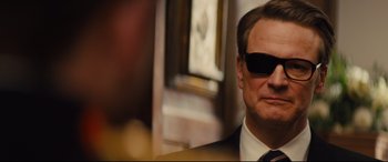 Movie still from “Kingsman: The Golden Circle” (2017), directed by Matthew Vaughn – A person wearing a suit and sunglasses; Close Up shot, Low angle
