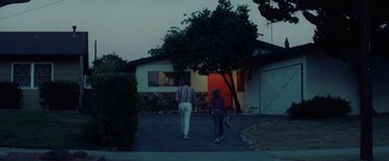 Movie still from “Licorice Pizza” (2021), directed by Paul Thomas Anderson – A man and a woman walking down a street; Wide shot, Low angle