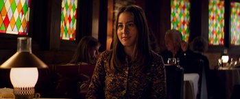 Movie still from “Licorice Pizza” (2021), directed by Paul Thomas Anderson – A woman sitting at a table in front of a stained glass window; Close Up shot, Over the shoulder angle