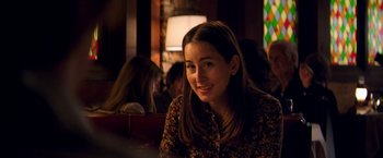 Movie still from “Licorice Pizza” (2021), directed by Paul Thomas Anderson – A woman sitting at a table in front of a lamp; Close Up shot, Over the shoulder angle
