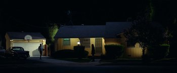 Movie still from “Licorice Pizza” (2021), directed by Paul Thomas Anderson – A person walking in front of a house at night; Extreme Wide shot, Low angle