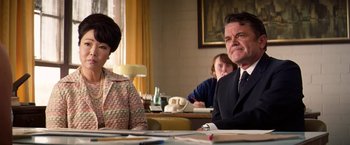 Movie still from “Licorice Pizza” (2021), directed by Paul Thomas Anderson – A man and a woman sitting at a table in a room; Medium shot, Over the shoulder angle