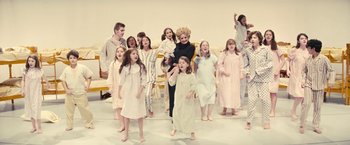 Movie still from “Licorice Pizza” (2021), directed by Paul Thomas Anderson – A group of people standing in a room; Wide shot, High angle