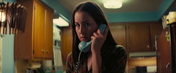 Movie still from “Licorice Pizza” (2021), directed by Paul Thomas Anderson – A woman holding a phone up to her ear; Close Up shot, Low angle