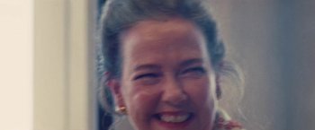 Movie still from “Licorice Pizza” (2021), directed by Paul Thomas Anderson – A woman's face smiling; Close Up shot, Low angle
