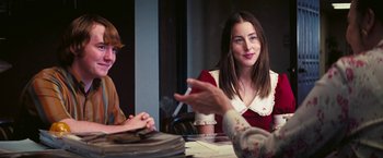 Movie still from “Licorice Pizza” (2021), directed by Paul Thomas Anderson – A woman sitting at a table talking to another woman; Medium shot, Over the shoulder angle