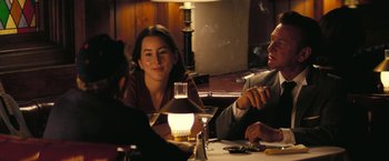 Movie still from “Licorice Pizza” (2021), directed by Paul Thomas Anderson – A group of people sitting around a table; Medium shot, Over the shoulder angle