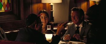 Movie still from “Licorice Pizza” (2021), directed by Paul Thomas Anderson – A group of people sitting at a table with drinks; Medium shot, Over the shoulder angle
