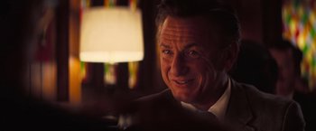 Movie still from “Licorice Pizza” (2021), directed by Paul Thomas Anderson – A man smiling for the camera; Close Up shot, Over the shoulder angle