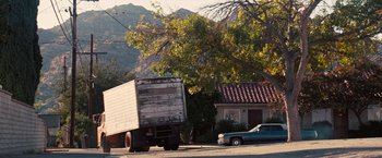 Movie still from “Licorice Pizza” (2021), directed by Paul Thomas Anderson – A truck parked on the side of the road near a house; Extreme Wide shot, Low angle