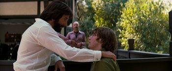 Movie still from “Licorice Pizza” (2021), directed by Paul Thomas Anderson – A man and a boy are hugging each other outside; Medium shot, Over the shoulder angle