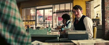 Movie still from “Licorice Pizza” (2021), directed by Paul Thomas Anderson – Two people sitting at a table in a restaurant; Medium shot, Over the shoulder angle