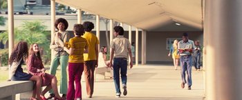 Movie still from “Licorice Pizza” (2021), directed by Paul Thomas Anderson – A group of people walking down a sidewalk; Wide shot, Low angle