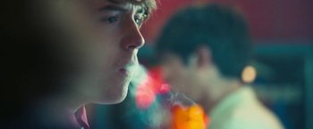 Movie still from “Licorice Pizza” (2021), directed by Paul Thomas Anderson – A young man smoking a cigarette in front of a mirror; Close Up shot, Over the shoulder angle