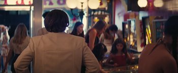 Movie still from “Licorice Pizza” (2021), directed by Paul Thomas Anderson – A group of people sitting at a table; Medium shot, Over the shoulder angle