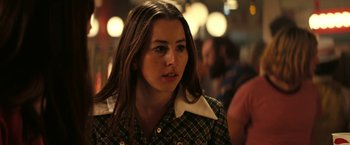 Movie still from “Licorice Pizza” (2021), directed by Paul Thomas Anderson – A person with long brown hair; Close Up shot, Over the shoulder angle