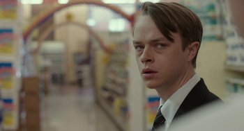 Movie still from “Life After Beth” (2014), directed by Jeff Baena – A man wearing a suit and tie standing in a store; Close Up shot, Over the shoulder angle