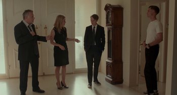 Movie still from “Life After Beth” (2014), directed by Jeff Baena – A man and a woman are standing in front of a grandfather clock; Wide shot, Over the shoulder angle