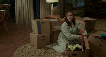 Movie still from “Life After Beth” (2014), directed by Jeff Baena – A woman sitting on the floor in front of boxes; Medium shot, High angle